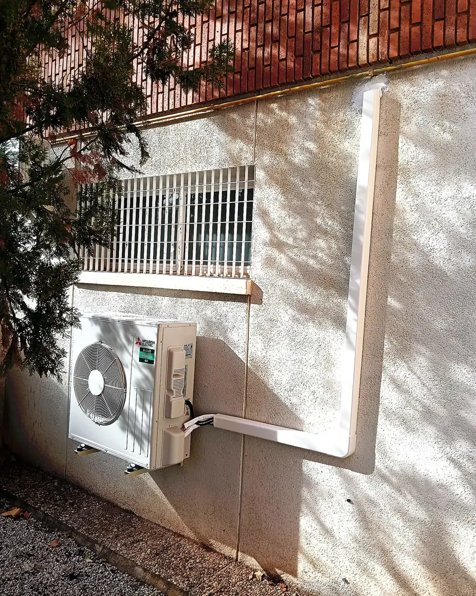 Unidad exterior de aire acondicionado en vivienda unifamiliar con jardín